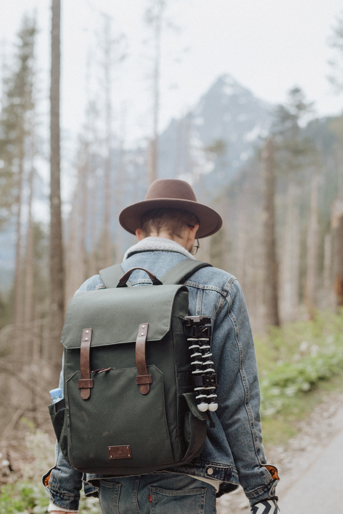 Man with Backpack Walking on the Road Near Trees